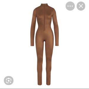 SKIMS ALL-IN-ONE SHINE MOCK
NECK LONG SLEEVE ONESIE | CARAMEL/L